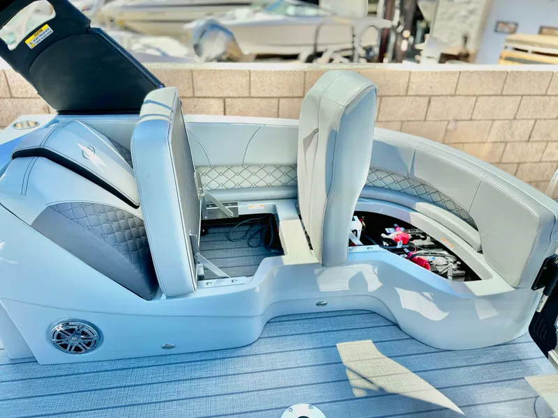 Slide: The Image of 2025 Manitou 23 LX RFXW boat interior with gray seating and storage compartments. - 22