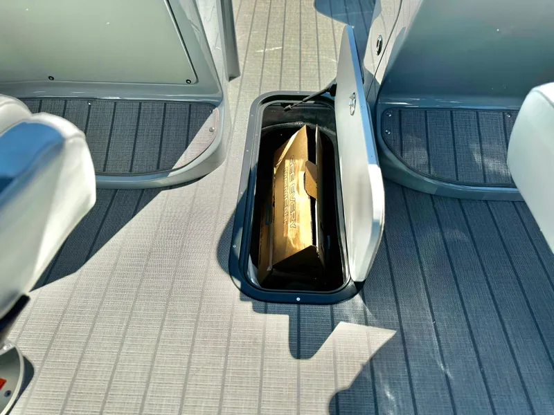 Slide: The Image of 2025 Manitou 23 LX RFXW boat storage compartment with open hatch. - 23