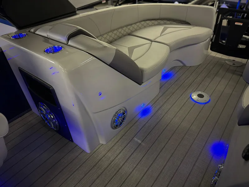Slide: The Image of Luxurious interior of 2025 Manitou 23 LX RFXW pontoon boat with ambient blue lighting. - 26