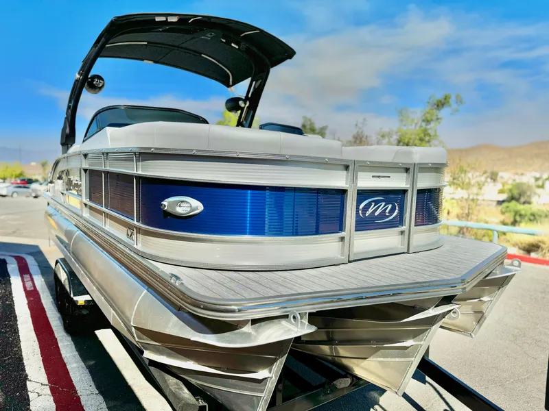 Slide: The Image of 2025 Manitou 23 LX RFXW pontoon boat with sleek design and blue accents. - 3