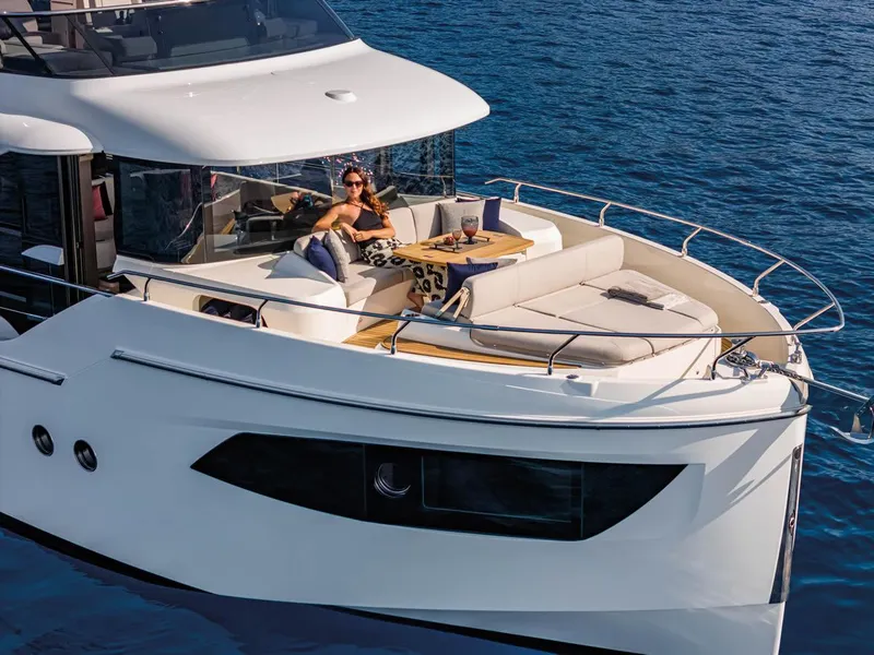 Slide: The Image of 2025 Absolute 53 Navetta yacht with lounging area on calm blue water. - 3