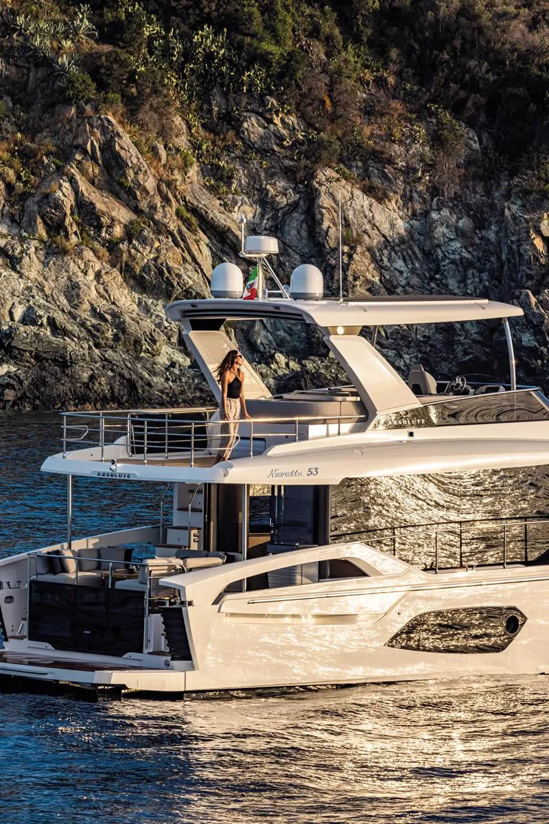 Slide: The Image of Luxury Absolute 53 Navetta yacht cruising near rocky coastline, 2025 model. - 4