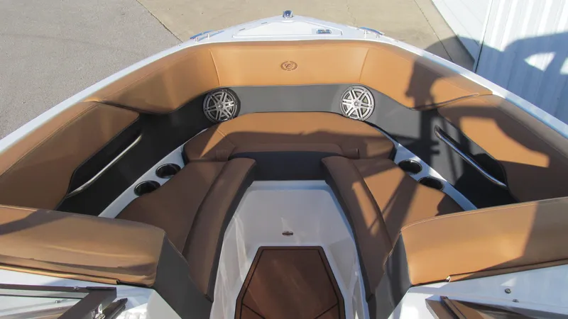 Slide: The Image of 2025 Cobalt CS23 boat interior with brown seating and cup holders. - 10
