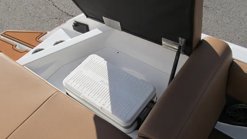 Slide: The Image of 2025 Cobalt CS23 boat storage compartment with cooler and cup holders. - 15