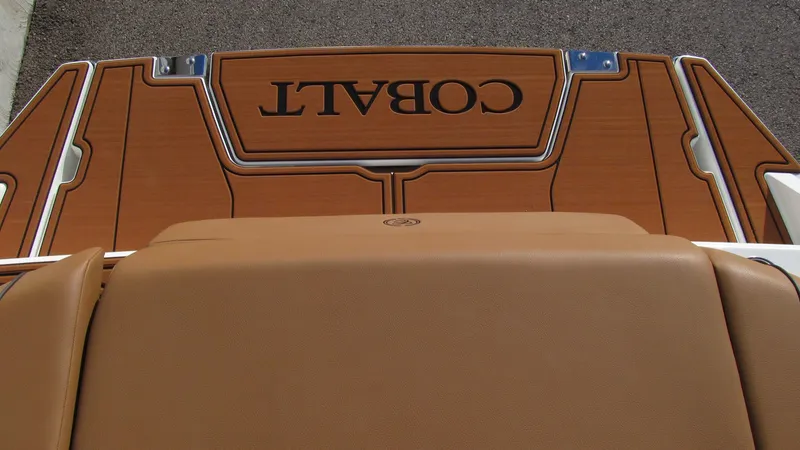 Slide: The Image of 2025 Cobalt CS23 boat deck with tan upholstery and wood finish. - 16