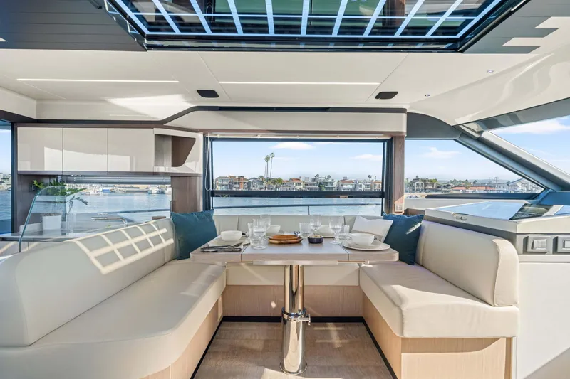 Slide: The Image of Luxurious interior of 2026 Absolute 48 Coupe yacht with elegant dining area and waterfront view. - 23