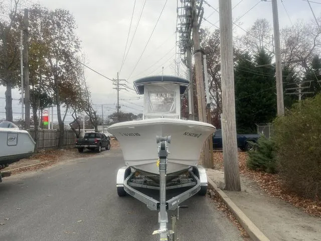 Slide: The Image of 2024 Sea Hunt Ultra 219 boat on trailer, parked on a suburban street. - 3