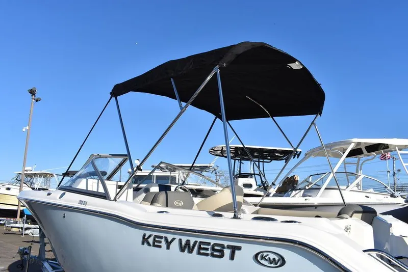 Slide: The Image of 2025 Key West 203 DFS boat with canopy, docked under clear blue sky. - 6