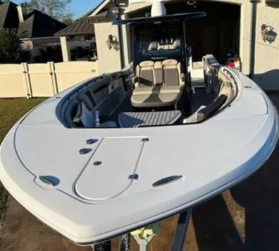 Slide: The Image of 2022 Tidewater 320 CC Adventure boat in driveway, showcasing sleek design and spacious seating. - 2
