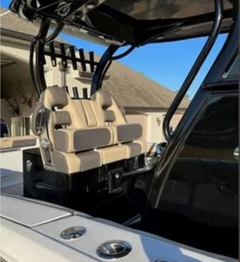 Slide: The Image of 2022 Tidewater 320 CC Adventure boat with beige seating and rod holders. - 8