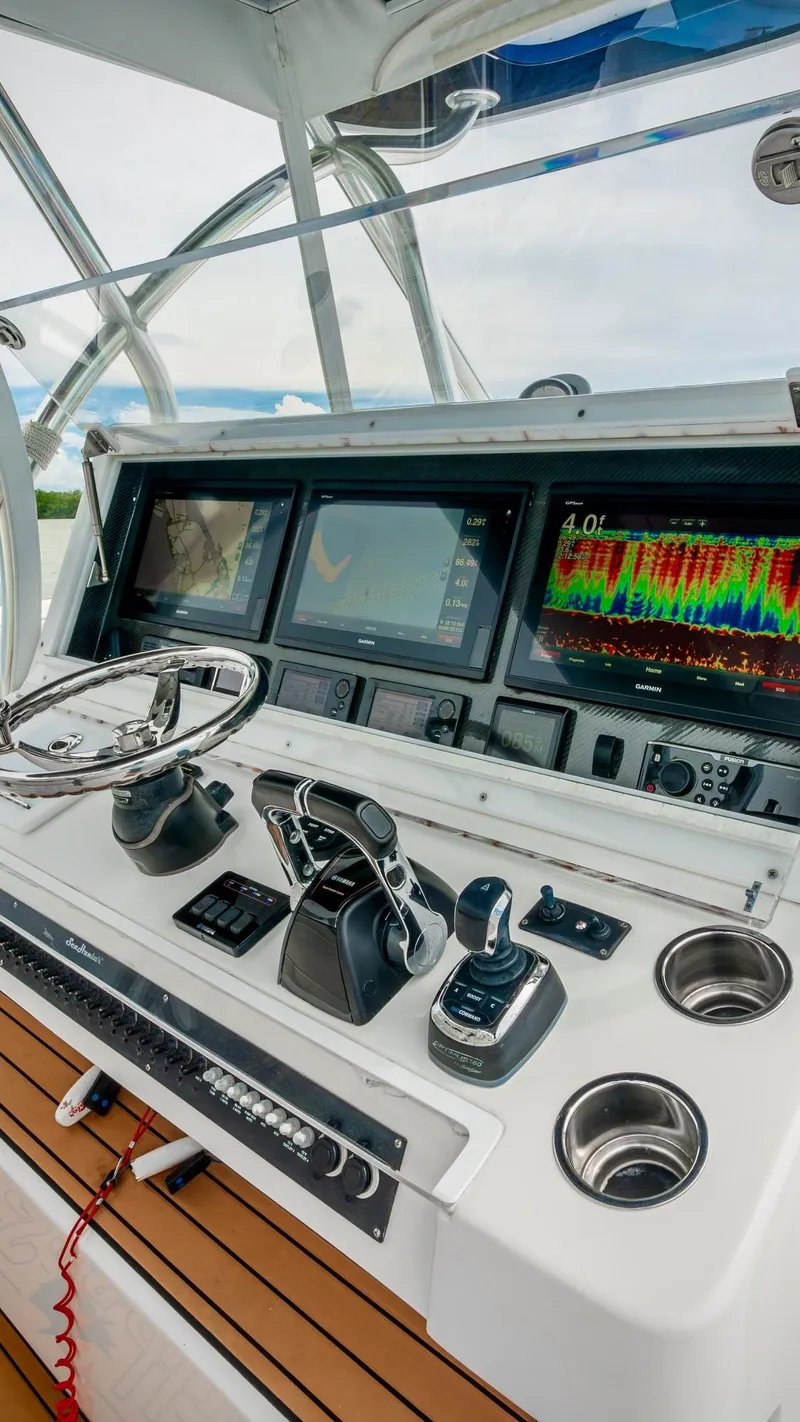 Slide: The Image of Control panel of 2017 SeaHunter 45 Tournament boat with navigation screens and steering wheel. - 11
