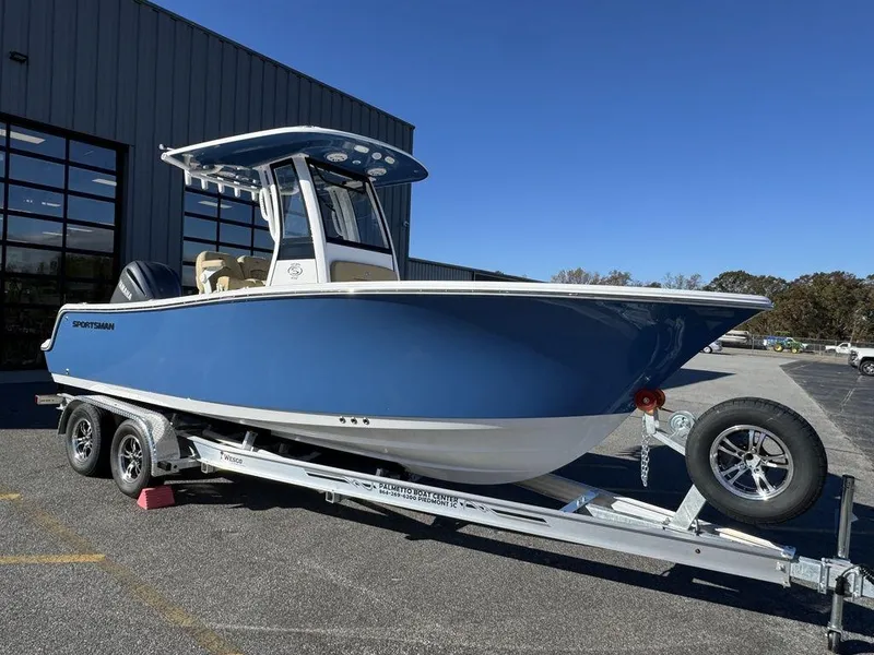 The Image of 2025 Sportsman Open 212 boat on trailer, blue hull, parked outdoors. - 0