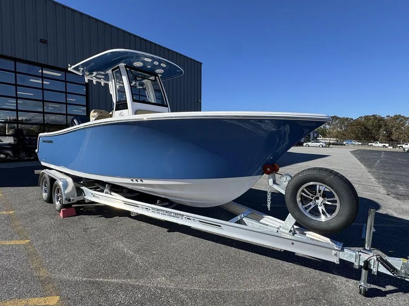 Slide: The Image of 2025 Sportsman Open 212 boat on trailer, blue hull, parked outdoors. - 2