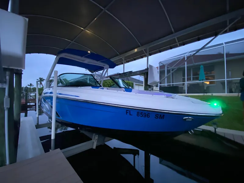 Slide: The Image of 2020 Chaparral 223 Vortex VRX boat docked under a canopy. - 2