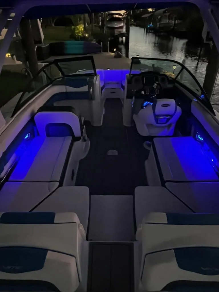 Slide: The Image of 2020 Chaparral 223 Vortex VRX boat with blue interior lighting at night. - 25