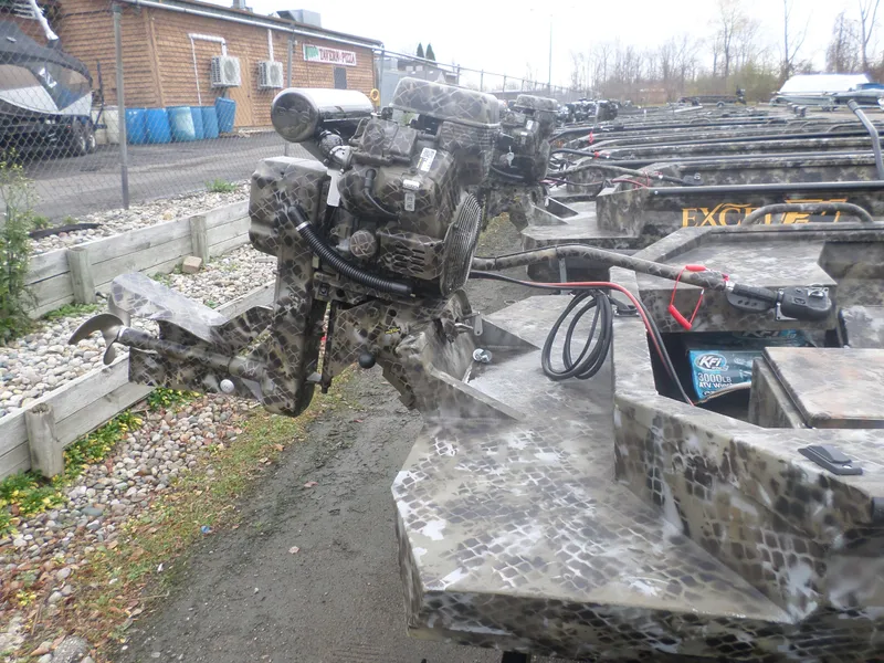 Slide: The Image of Camouflage-patterned Excel 1860 Pro boat with motor, parked outdoors, 2025 model. - 5