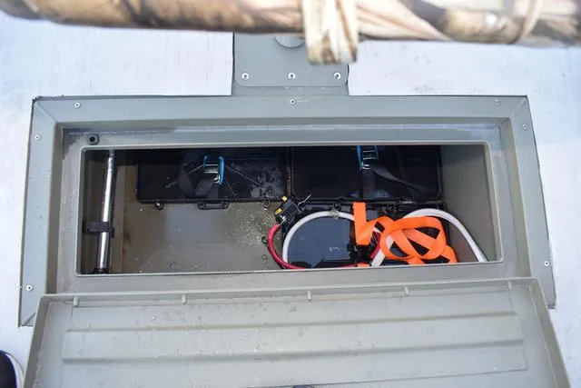 Slide: The Image of 2023 Tracker GRIZZLY® 1648 SC storage compartment with battery and wiring. - 13