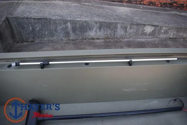 Slide: The Image of 2023 Tracker GRIZZLY® 1648 SC boat interior with rod holder and Thayer's Marine logo. - 18