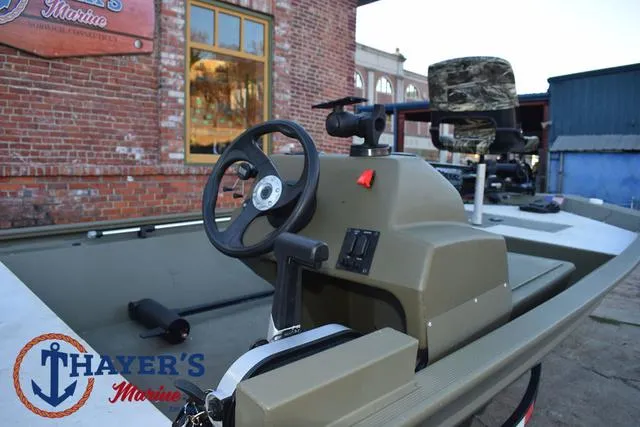 Slide: The Image of 2023 Tracker GRIZZLY® 1648 SC boat with steering wheel, camo seat, and Thayer's Marine logo. - 26