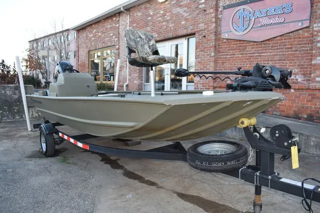 Slide: The Image of 2023 Tracker GRIZZLY® 1648 SC boat on trailer, parked outside brick building. - 28