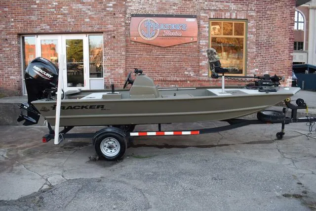 Slide: The Image of 2023 Tracker GRIZZLY® 1648 SC boat on trailer, parked outside a brick building. - 31