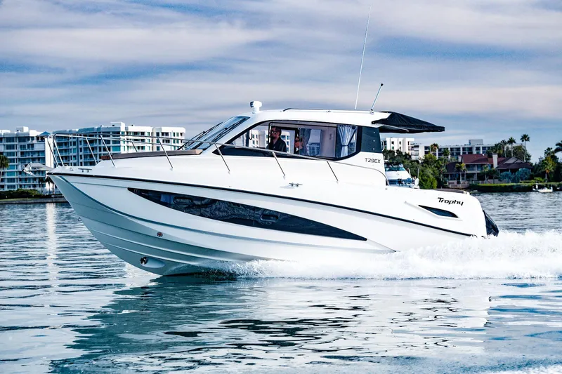 Slide: The Image of 2024 Bayliner Trophy T29EX cruising on water, modern design, cityscape background. - 11