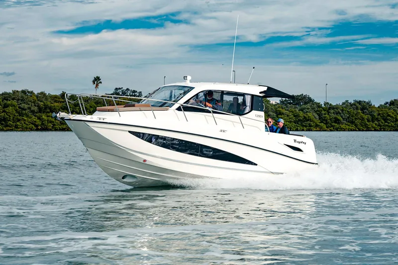 Slide: The Image of 2024 Bayliner Trophy T29EX cruising on water, showcasing sleek design and performance. - 2