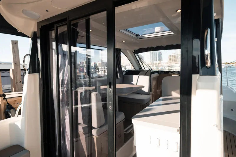 Slide: The Image of 2024 Bayliner Trophy T29EX interior with modern seating and glass doors. - 7