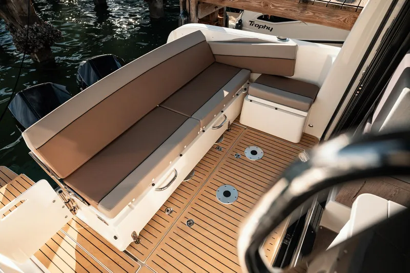 Slide: The Image of 2024 Bayliner Trophy T29EX boat interior with cushioned seating and teak flooring. - 8