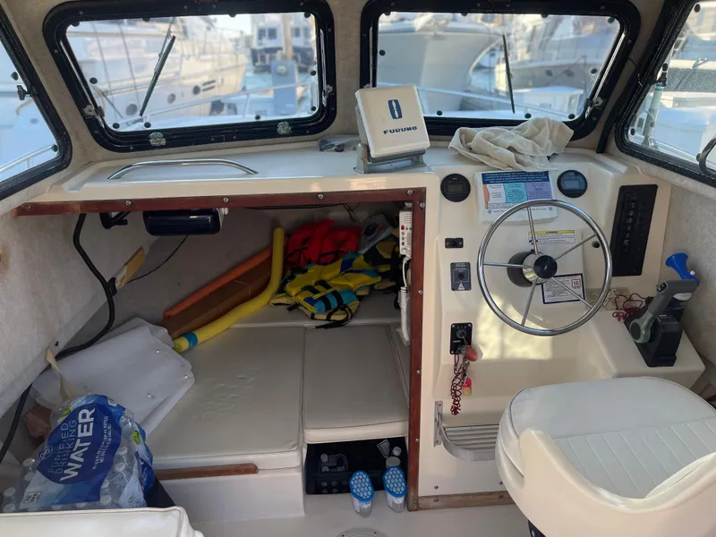 Slide: The Image of Interior of a 2001 Parker 2502 boat with steering wheel and equipment. - 11