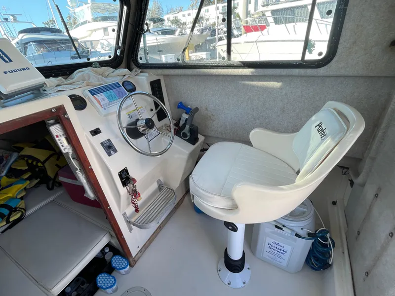 Slide: The Image of Interior of a 2001 Parker 2502 boat with steering wheel and captain's chair. - 12