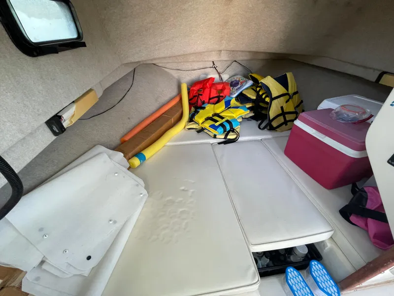 Slide: The Image of Interior of a 2001 Parker 2502 boat with life jackets and a cooler. - 15