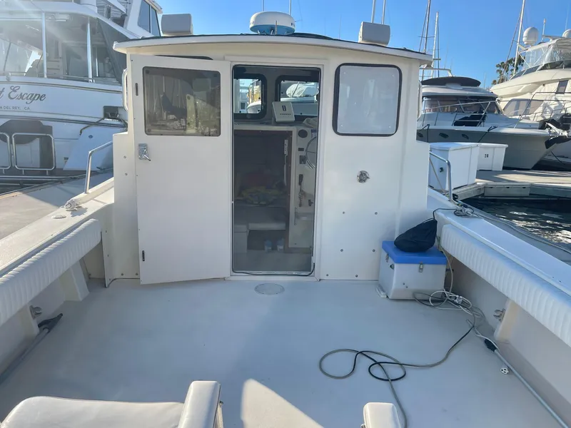 Slide: The Image of 2001 Parker 2502 boat docked, featuring spacious deck and cabin entrance. - 5