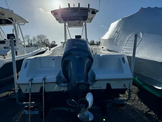 Slide: The Image of 2013 Tidewater 230 CC Adventure boat with outboard motor, docked under clear sky. - 3
