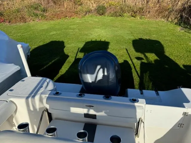 Slide: The Image of 2013 Tidewater 230 CC Adventure boat with outboard motor, parked on grass. - 4