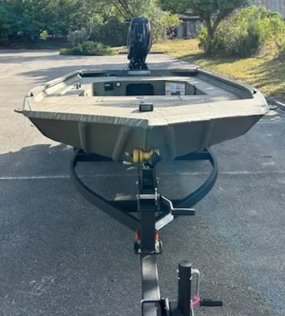 Slide: The Image of 2025 Tracker Grizzly 1654 T Sportsman boat on trailer in outdoor setting. - 2