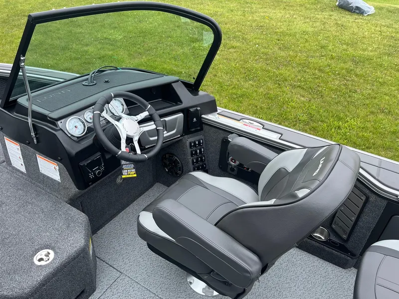 Slide: The Image of 2025 Lund 1975 Pro-V boat interior with steering wheel and captain's chair. - 10