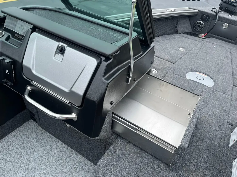 Slide: The Image of Interior of 2025 Lund 1975 Pro-V boat, featuring storage compartment and seating area. - 15