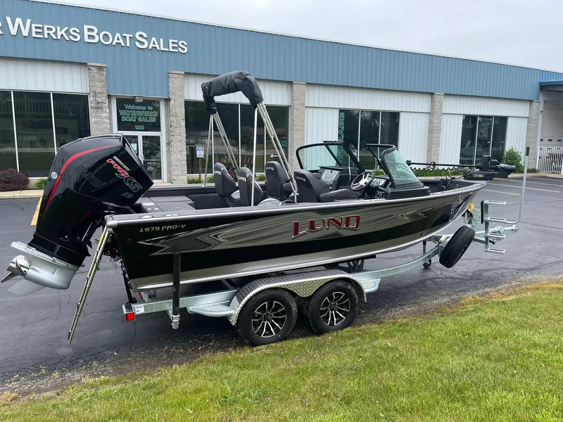 Slide: The Image of 2025 Lund 1975 Pro-V boat on trailer outside dealership. - 2