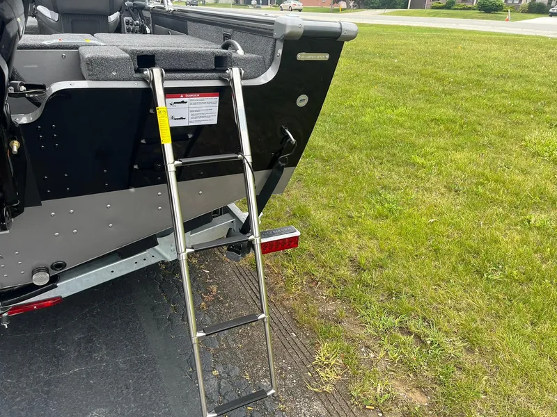 Slide: The Image of Lund 1975 Pro-V boat with ladder, parked on grass, 2025 model. - 27