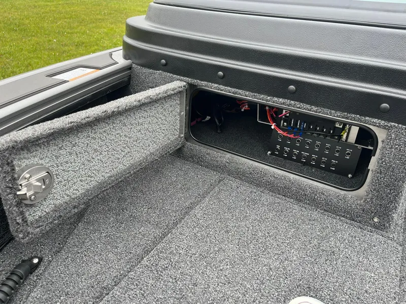 Slide: The Image of 2025 Lund 1975 Pro-V boat interior with open storage compartment and electrical panel. - 37