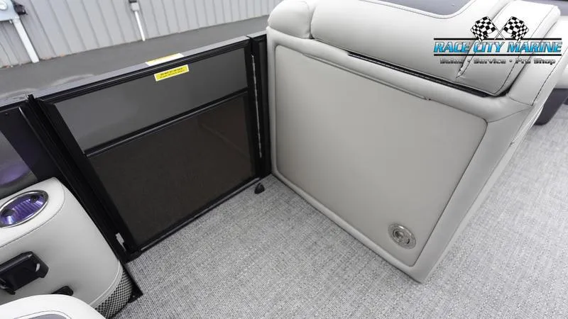 Slide: The Image of 2025 Barletta C22UC boat interior with open storage compartment and cup holders. - 23