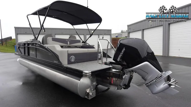 Slide: The Image of 2025 Barletta C22UC pontoon boat with Mercury engine, parked outdoors. - 7