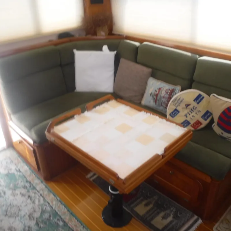 Slide: The Image of Cozy interior of 1998 Legacy 40' Flybridge with green seating and wooden table. - 21