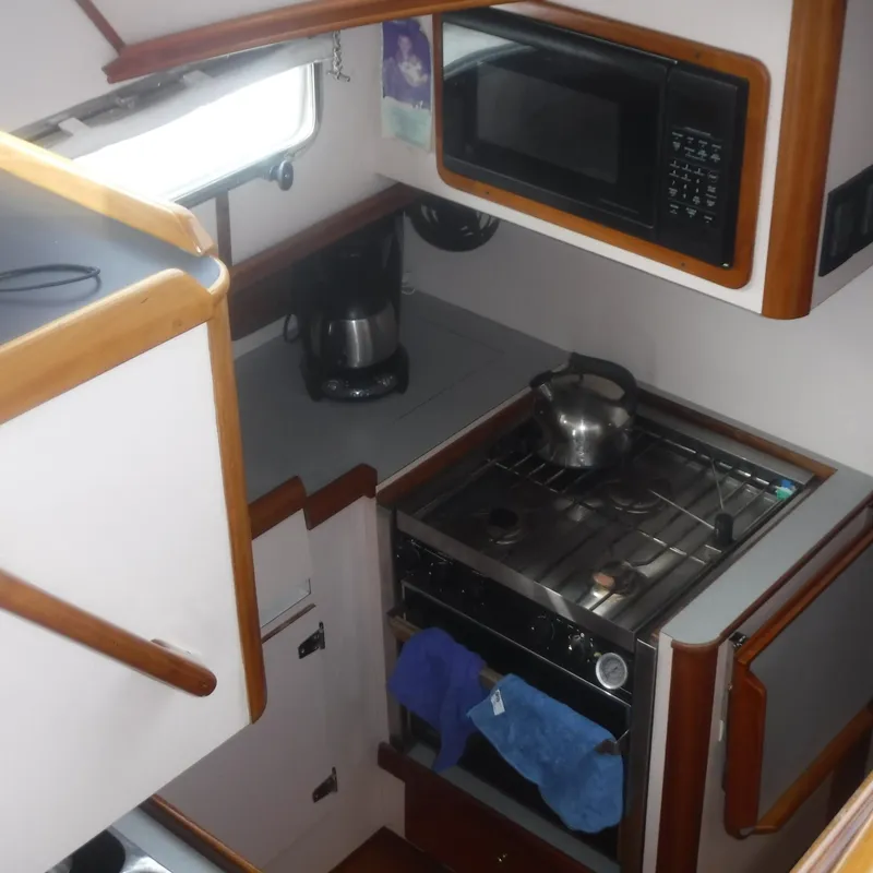 Slide: The Image of Legacy 40' Flybridge 1998 yacht kitchen with stove, microwave, and coffee maker. - 27