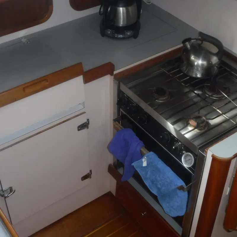Slide: The Image of Legacy 40' Flybridge 1998 galley with stove, kettle, and countertop. - 28