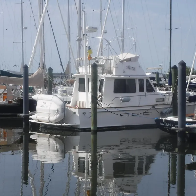 Slide: The Image of 1998 Legacy 40' Flybridge yacht docked in marina, reflecting on water. - 3