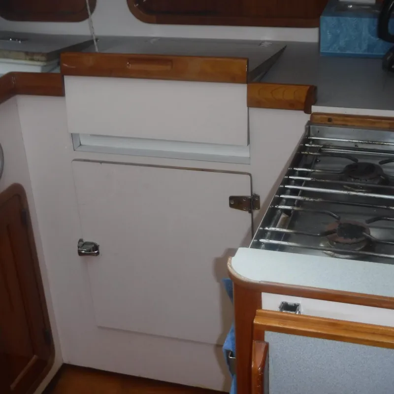 Slide: The Image of Legacy 40' Flybridge 1998 yacht kitchen with stove and storage cabinets. - 30