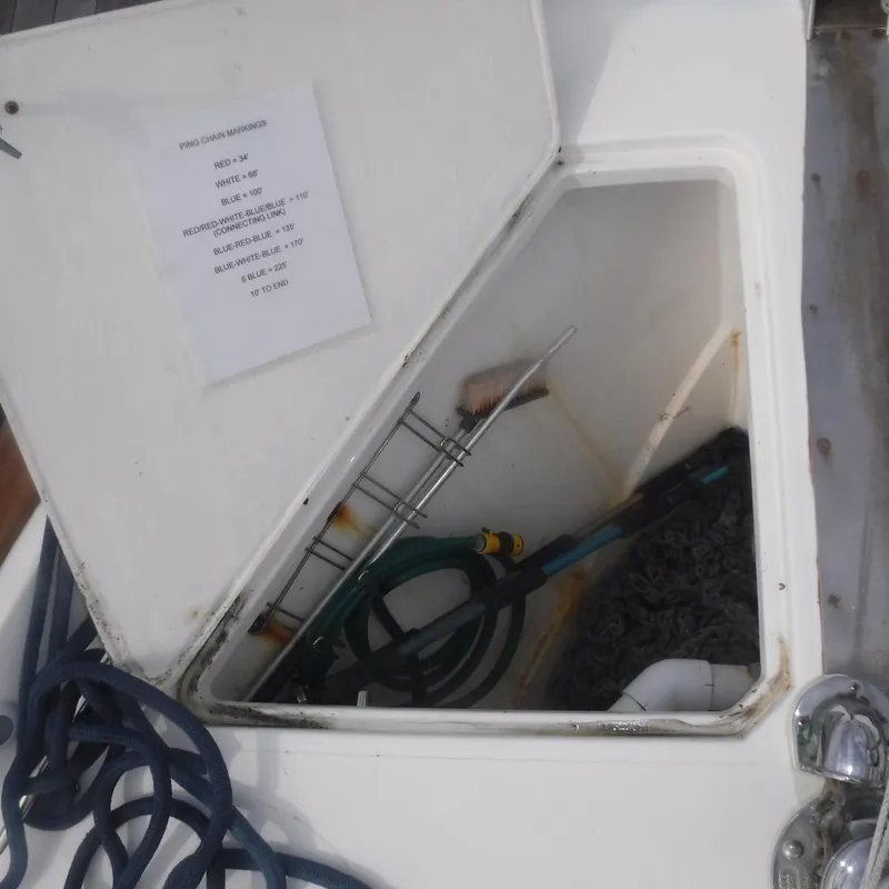 Slide: The Image of Open storage compartment on 1998 Legacy 40' Flybridge boat with cleaning supplies. - 37