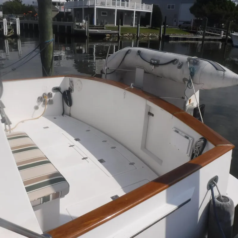 Slide: The Image of 1998 Legacy 40' Flybridge boat with striped seating, docked near waterfront homes. - 4